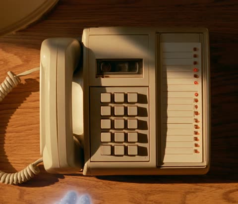 A glittering hand passes through the phone's handset. It can't pick it up. Cut