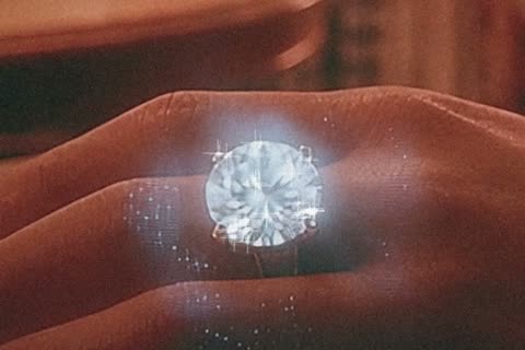 A hand wearing a glittering ring